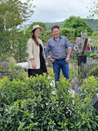 a man and woman standing in a garden